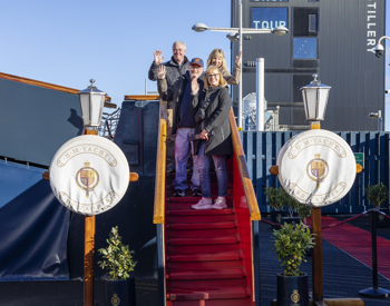 Visitors posing on the red-carpeted Royal Brow steps of the Royal Yacht Britannia, one of the best Edinburgh tourist attractions to visit