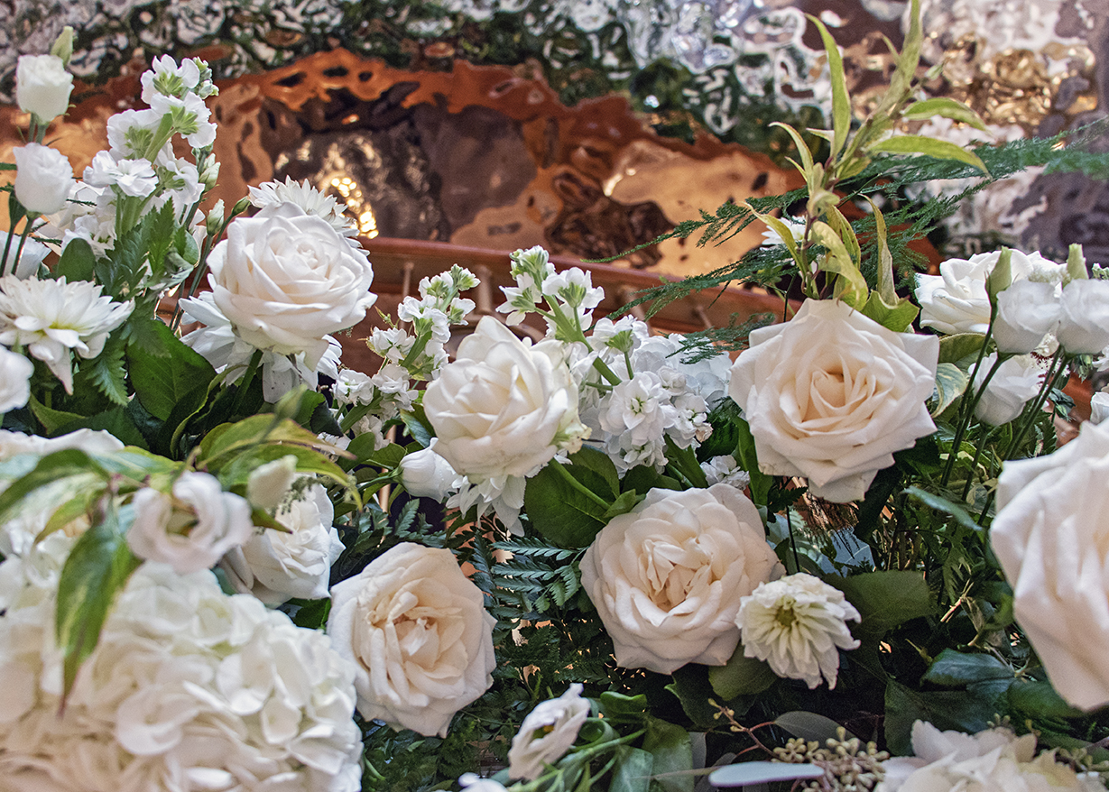 A display of cream flowers and roses.